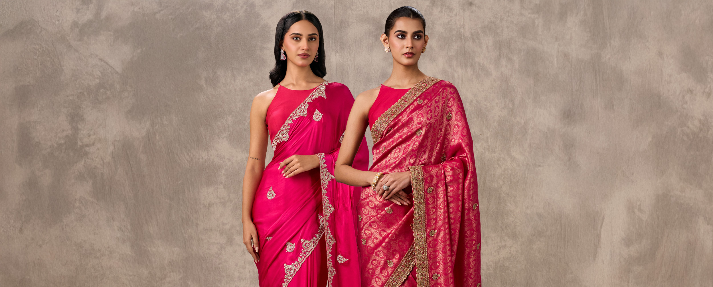 Two women showcasing complementary bridal party sarees: one in a magenta embroidered saree and one in a heavy pink Banarasi silk saree.