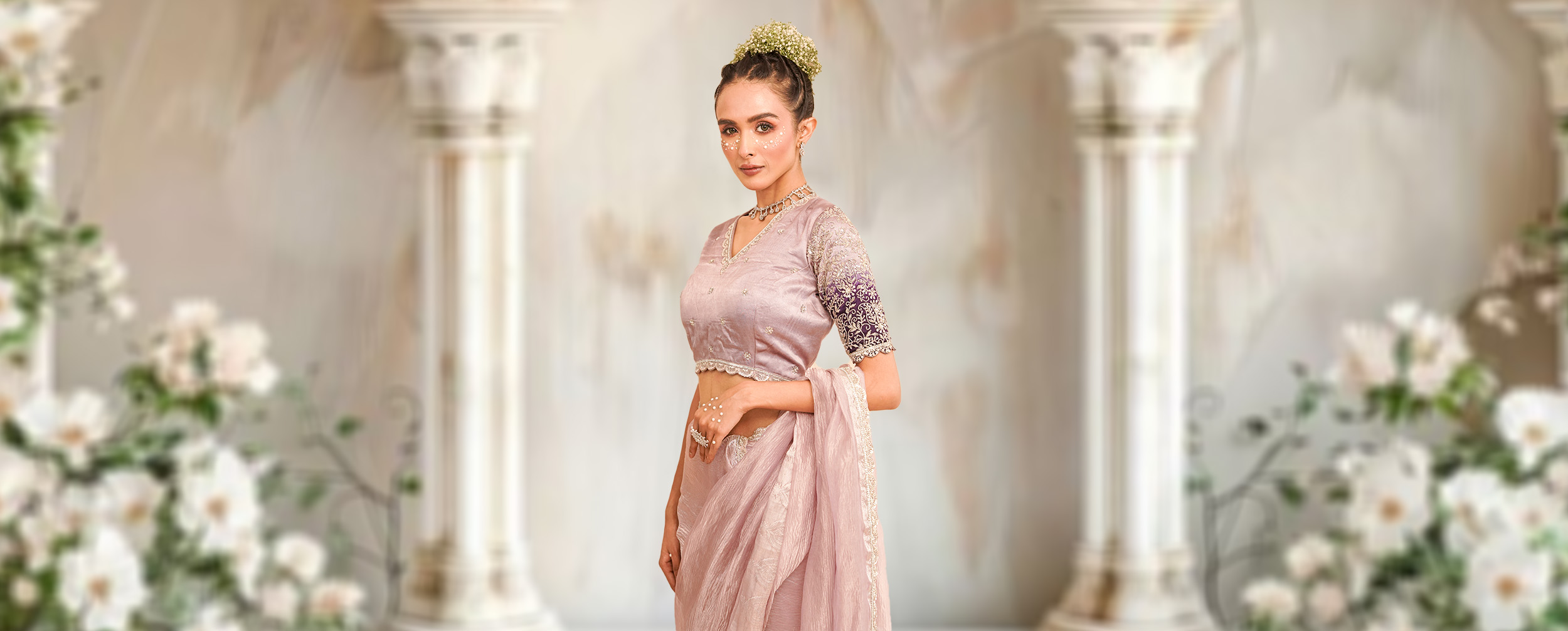Woman modeling a pre-draped lavender lehenga saree with a deep purple embroidered blouse, showcasing a modern event look.